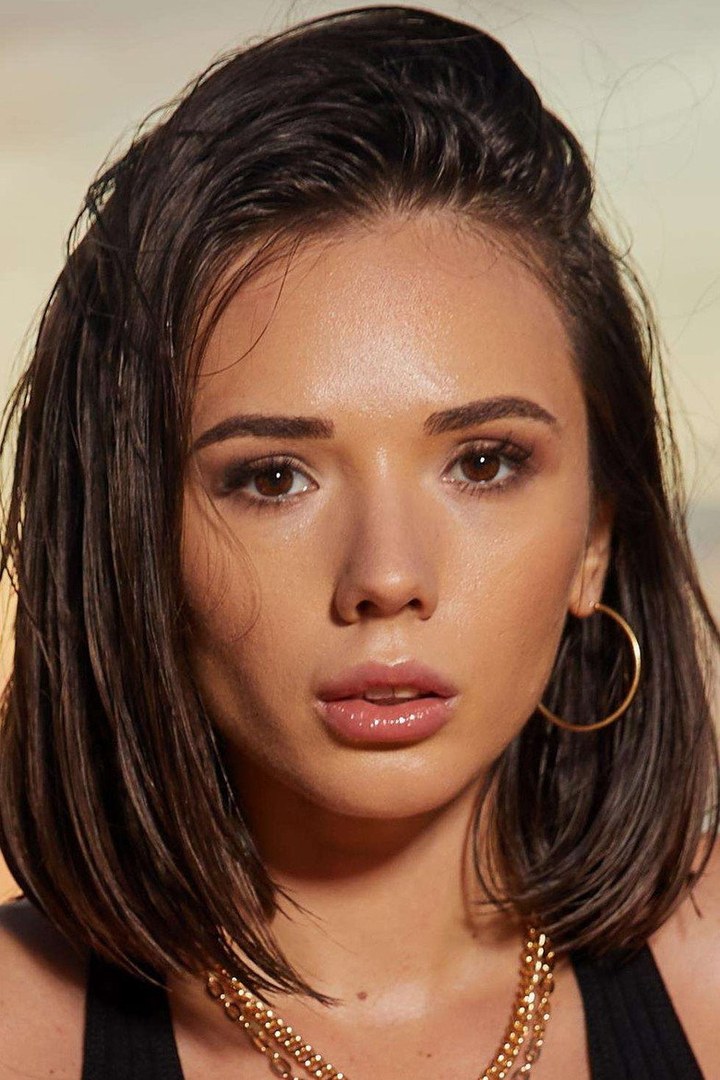 Retrato de Eve Sweet con pendientes de aro dorados y una cadena de oro